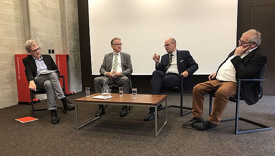 Personen diskutieren auf Podium