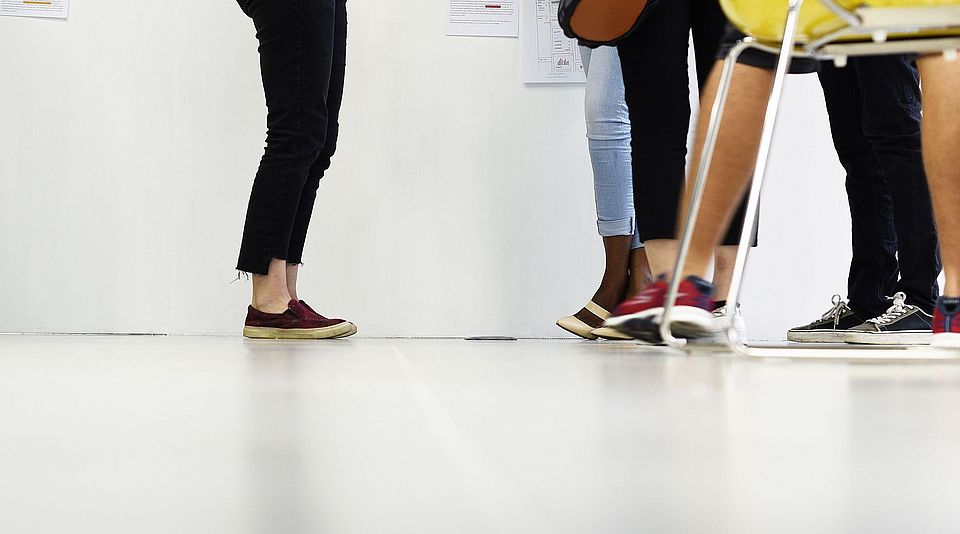 Studierende vor weisser Wand