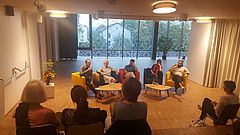 Menschen hören Podiumsdiskussion zu